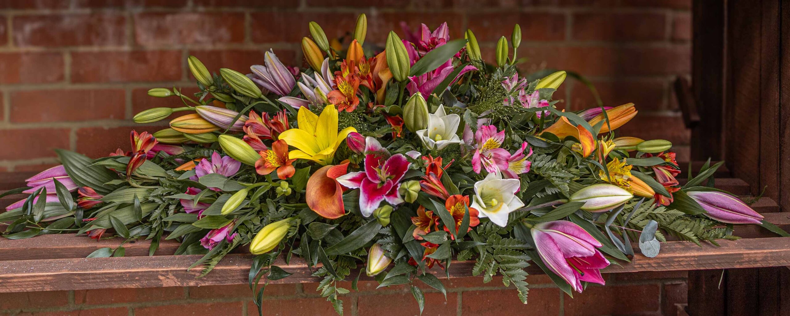 Brightly coloured casket spray