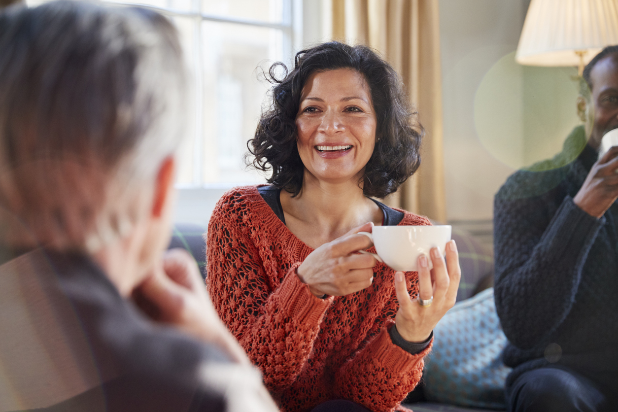 Woman drinking coffee with others